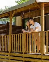 Camping Arc en Ciel - Accommodations - Couple on their cottage terrace