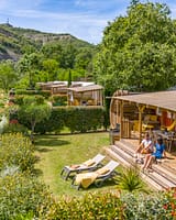 Camping La Plage Fleurie - Hébergements - Couple assis sur la terrasse de leur cottage