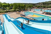 La Plage Fleurie campsite - Water park - Mother and her son under a waterfall on the splash pad