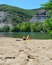 Camping Arc en Ciel - Activities - Woman lying on the beach by the Ardèche
