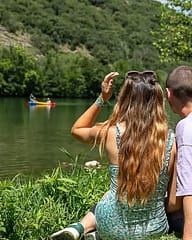Camping Arc en Ciel - Activities - Couple sitting on the grass by the Ardèche