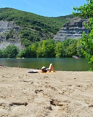Camping Arc en Ciel - Activit&eacute;s - Femme allong&eacute;e sur la plage au bord de l\'Ard&egrave;che