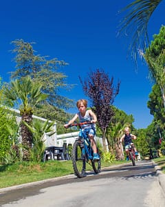 Camping l\'Hippocampe - Le domaine - Enfants faisant du vélo sur les allées piétonnes 