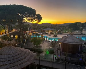 Camping les Tournels : Services - Vue des cabanes et de l'espace aquatique à la tombée de la nuit