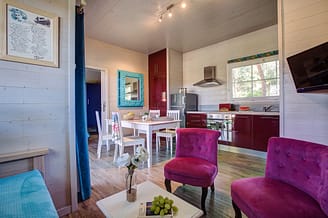 Camping Le Brasilia, Chalet les Marquises, woonkamer en keuken op de achtergrond