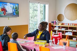 Camping Le Bois de Valmarie - Kinderen die Monopoly spelen met een groepsleider