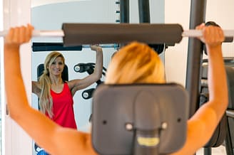 Camping Le Bois de Valmarie - Salle Fitness - Femme faisant de la musculation