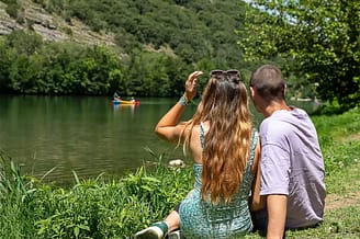 Camping Arc en Ciel - Activities - Couple sitting on the grass by the Ard&egrave;che