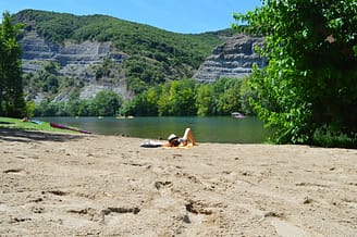 Camping Arc en Ciel - Activities - Woman lying on the beach by the Ard&egrave;che