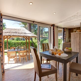 Camping Le Brasilia, Cottage Okavango, séjour et vue sur la terrasse