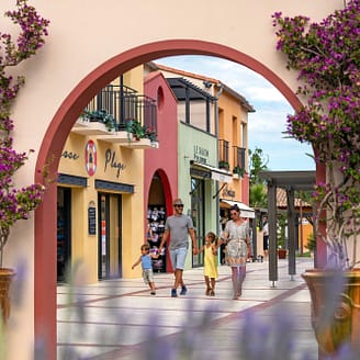 Camping Le Brasilia, services, famille marchant dans l\'allée de la place du village