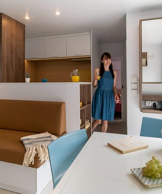 Camping la Sir&egrave;ne - H&eacute;bergements - Femme avec un verre de jus d\'orange dans un mobile home