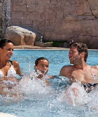Camping l\'Hippocampe - Parc aquatique - Couple et leurs enfants dans la pataugoire