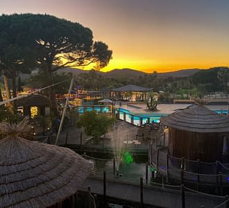 Camping les Tournels : Services - Vue des cabanes et de l'espace aquatique à la tombée de la nuit