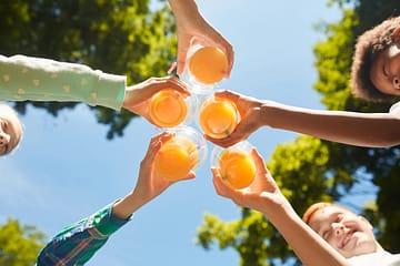 Ardèche - Enfants souriants tenant des verres avec du jus d\'orange