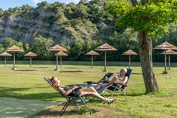 La Plage Fleurie campsite - Pitches - Couple stretched out on their sunloungers on the beach by the river