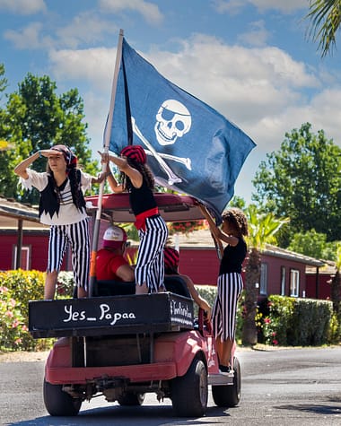 Camping Californie Plage - Le club enfants - Journée spéciale pirates avec des enfants déguisés portant un drapeau pirate