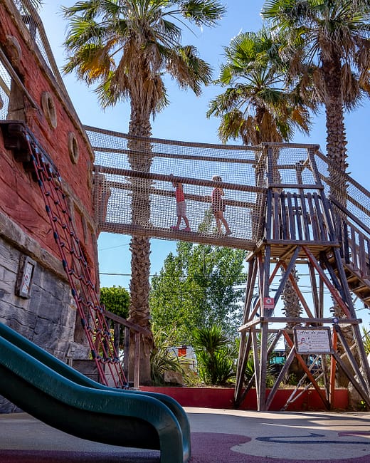 Camping Californie Plage - Galerie photo - Aire de jeux avec toboggans et pont suspendu dans l\'aire de jeux 